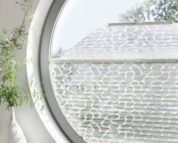 Weißes Plisse in einem kreisförmigen Fenster
